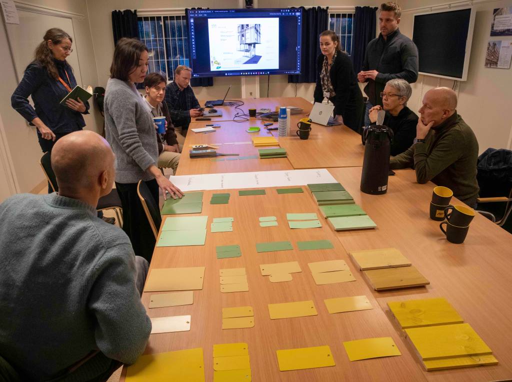 Adela Rubio-Gandia, arkitekt hos Henning Larsen går gjennom prosessen for fargevalget. Rundt bordet fra høyre - Per Reitan, prosjektsjef stiftelsen. Ingunn Moser, adm. direktør stiftelsen. Einar Grimstad, prosjektleder AF Gruppen. Maiken Veium Skotvedt, prosjektleder stiftelsen. Sivert Brukstuen, prosjektingeniør AF Gruppen. Melissa Lyby, kommunikasjonsrådgiver stiftelsen.  