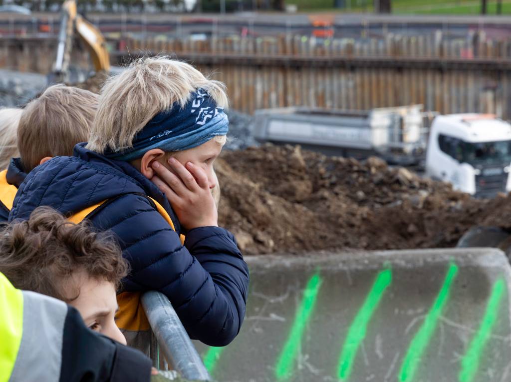 Store maskiner vekker stor fascinasjon blant barna på byggeplassen.