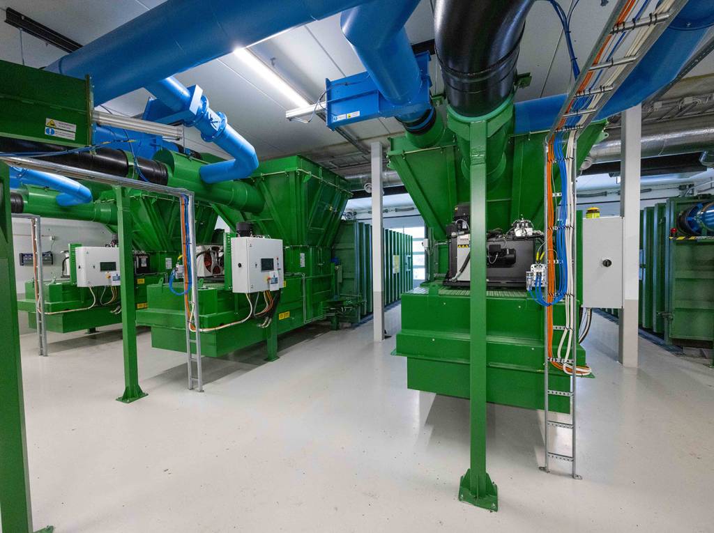 Et tilsvarende anlegg som dette, som ligger på Høn i Asker, skal bygges. Rørene i taket frakter avfallet, som først blir komprimert før det sendes inn i containerne. 