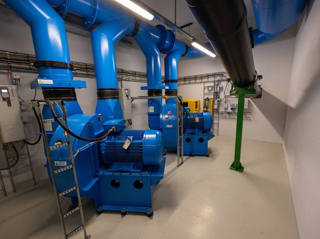 Fra et tilsvarende anlegg som er bygd på Høn i Asker: Her er to turbiner som skaper luftgjennomstrømningen som blåser posene med avfall gjennom rørsystemet under bakken og inn i miljøstasjonen og ned i containerne. 